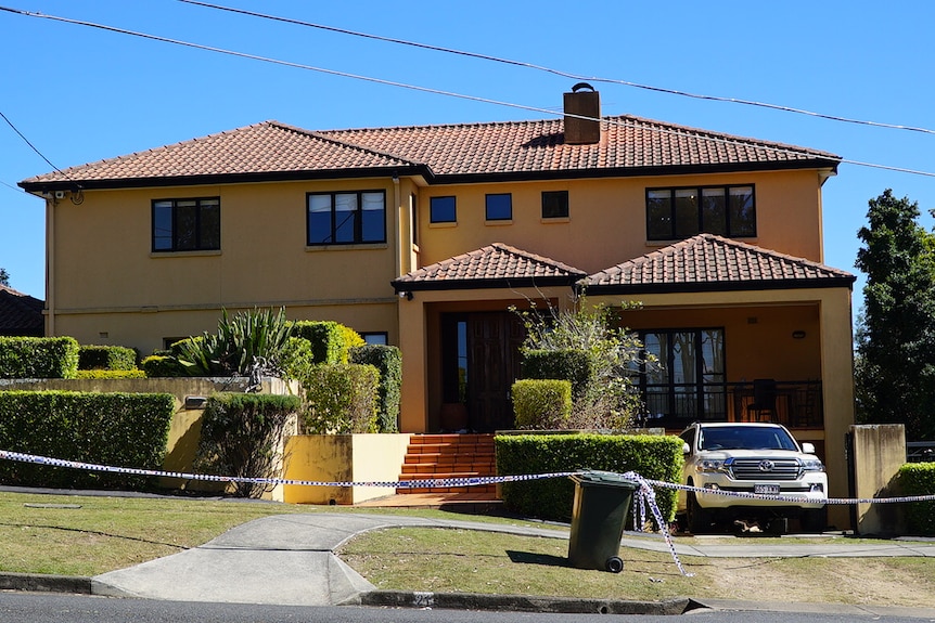 A yellow house with a 4WD in the driveway.