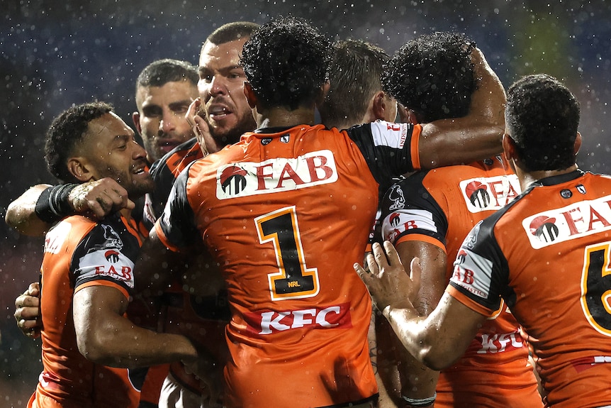 A group of rugby league players celebrate a win