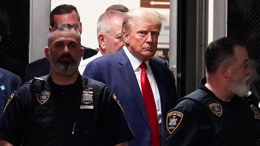 Donald Trump flanked by NYPD officers.