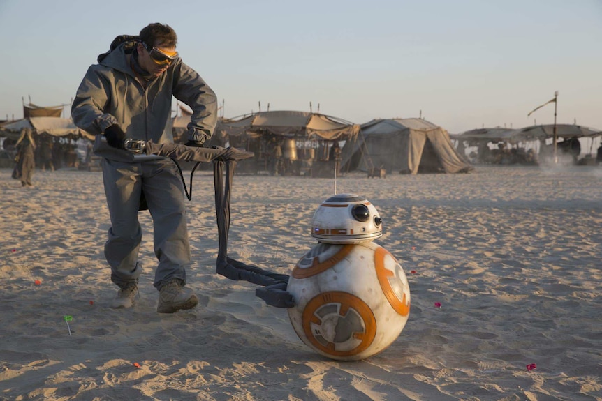 Brian Herring pushing BB-8 droid in a scene across sand during The Force Awakens