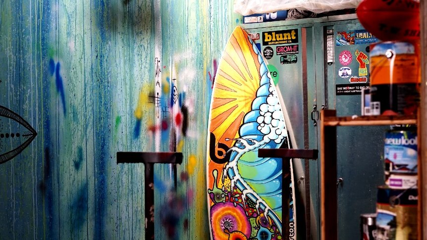 A painted surfboard resting in Jeremy Ievins colourful drying room