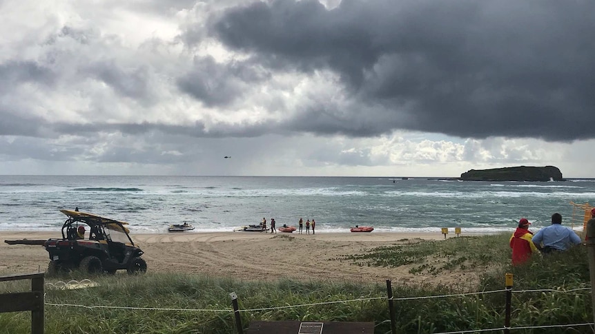 Emergency services including lifesavers, boats, helicopters, drones and police divers perform a rescue at Fingal Beach.