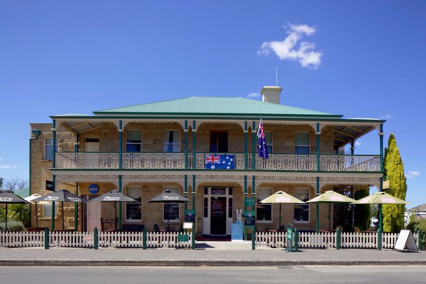 The exterior of the historic Richmond Arms Hotel, a two-storey sandstone building with wrought iron detailing.