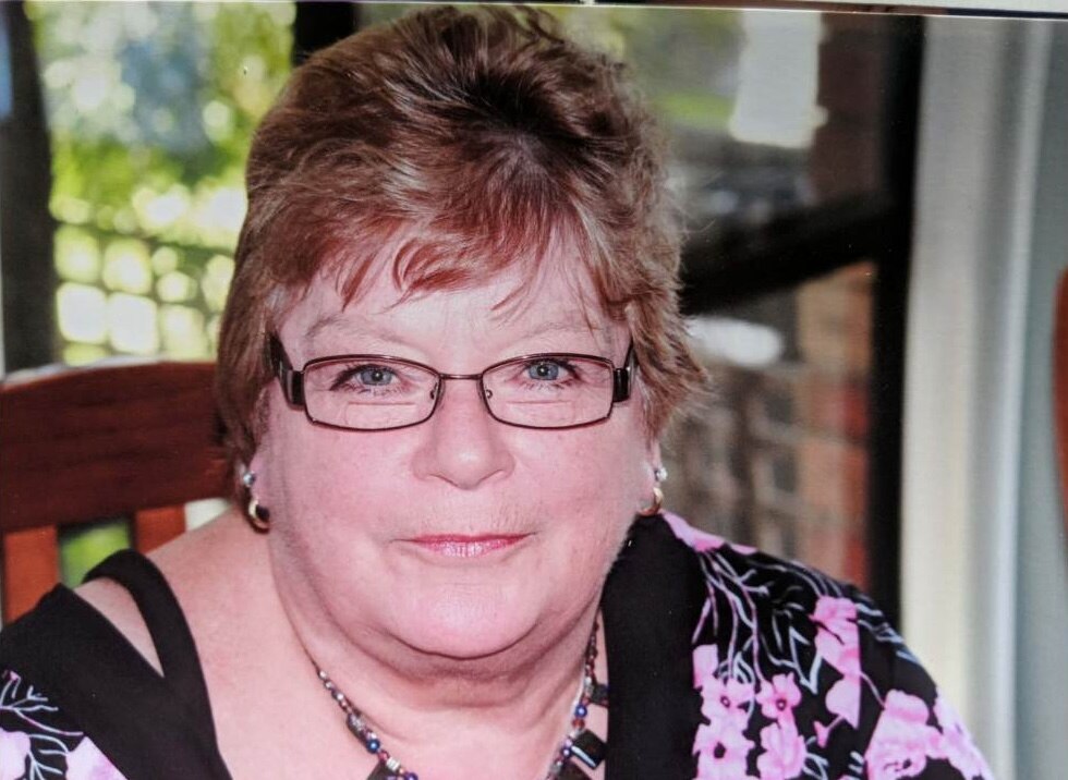 A woman with glasses smiling at the camera