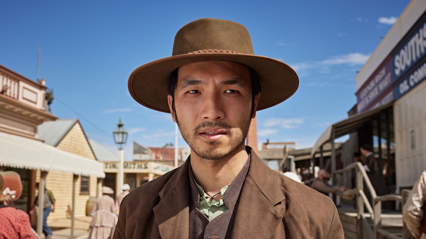 Close up of man in an Akubra with an early settler Australian backdrop