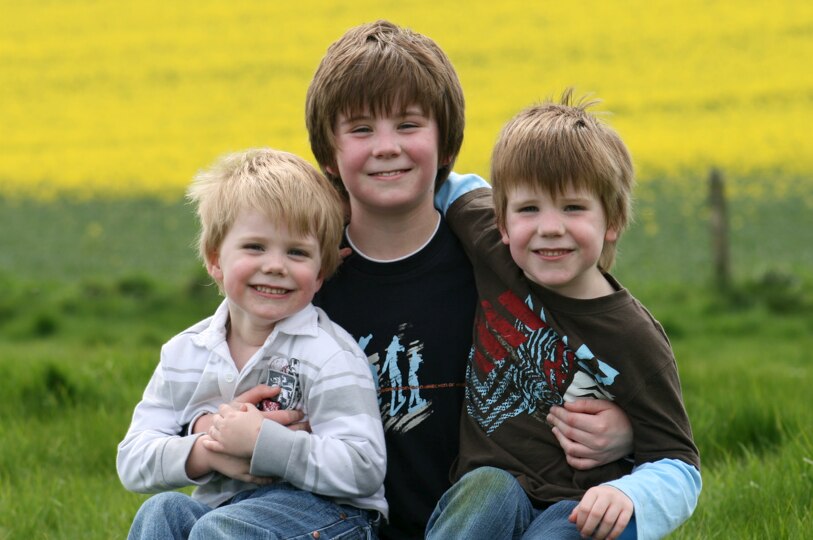 Elizabeth Jackson's three boys pose in front of a field.