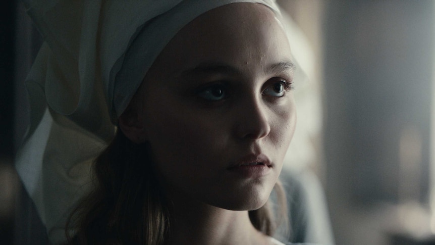 Actor Lily-Rose Depp as French princess Catherine, big eyes, white material wrapped around her head