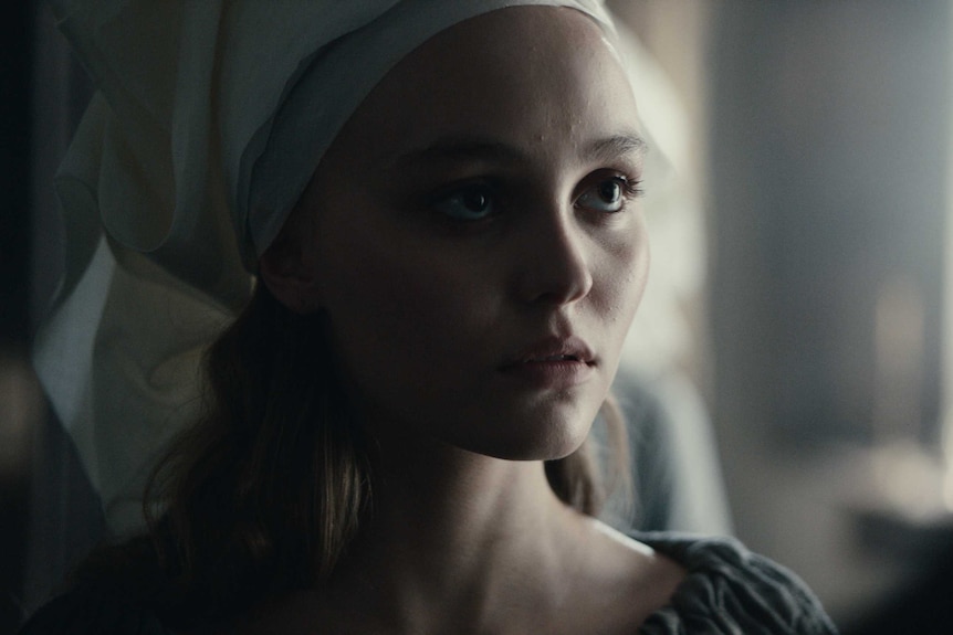 Actor Lily-Rose Depp as French princess Catherine, big eyes, white material wrapped around her head