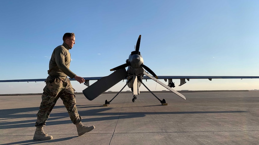 A member of the US Forces walks past a drone on an airbase in Iraq.