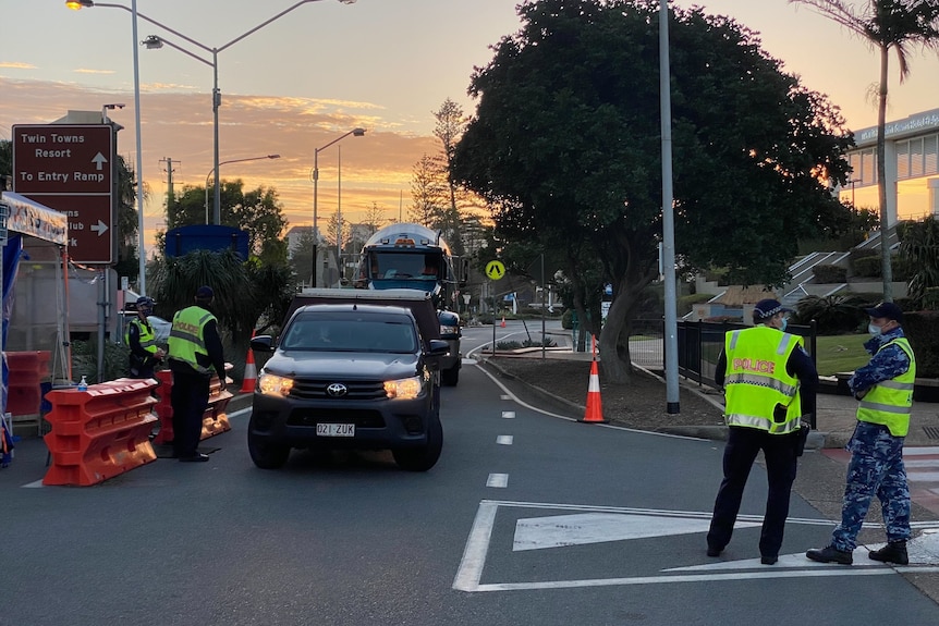 A car and police at a border checkpoint.