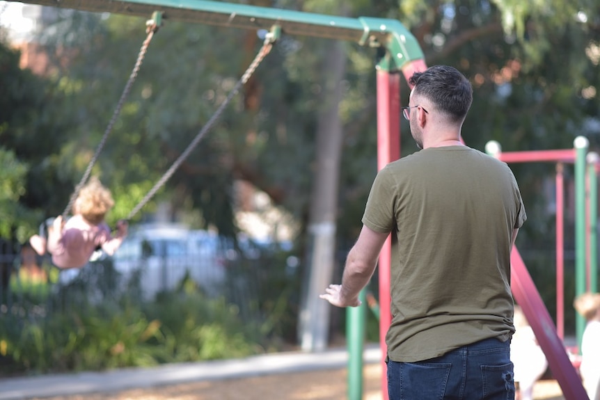 Patrick McIvor pushing child on a swing