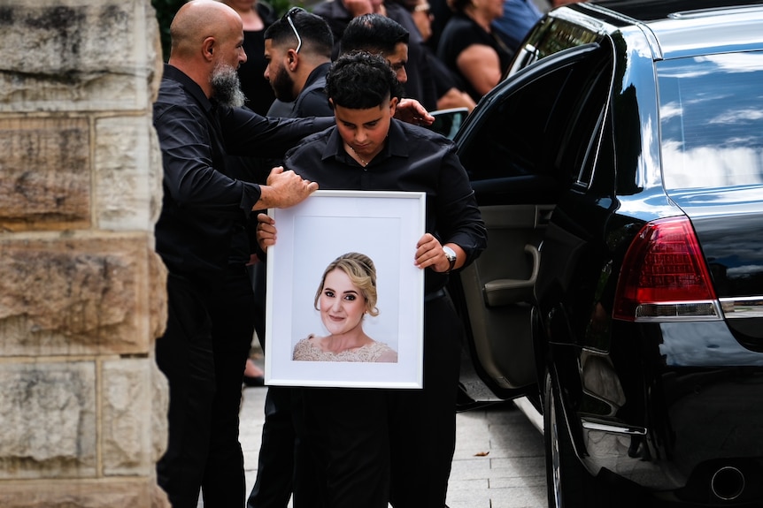 A man holding a picture of a woman 