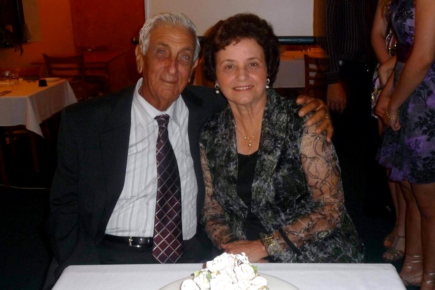 Elderly couple Sib and Maria Grasso in front of a cake marking their 50th anniversary