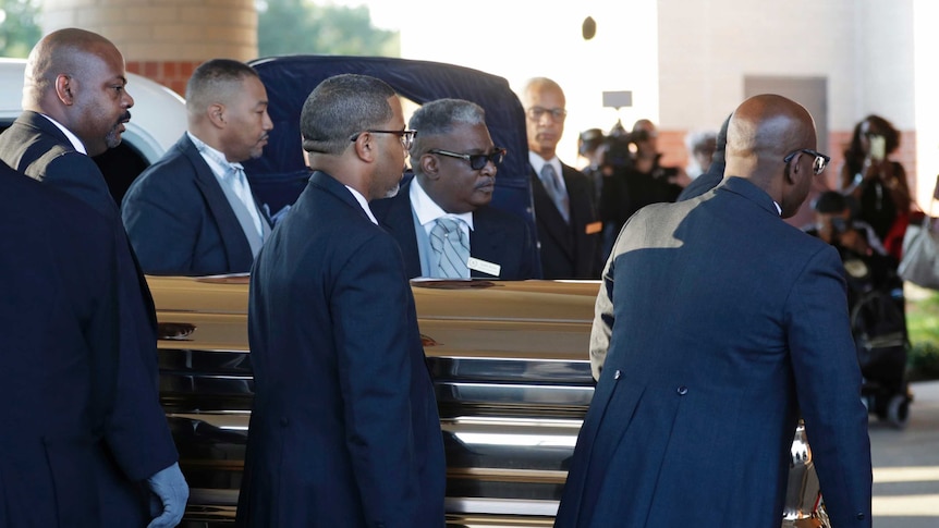 Pallbearers carry the gold casket of legendary singer Aretha Franklin.