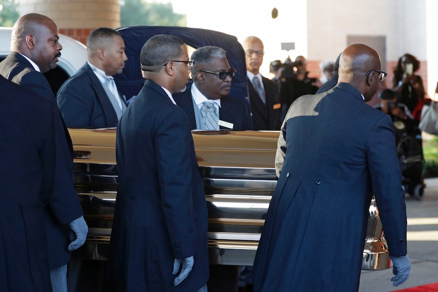 Pallbearers carry the gold casket of legendary singer Aretha Franklin.