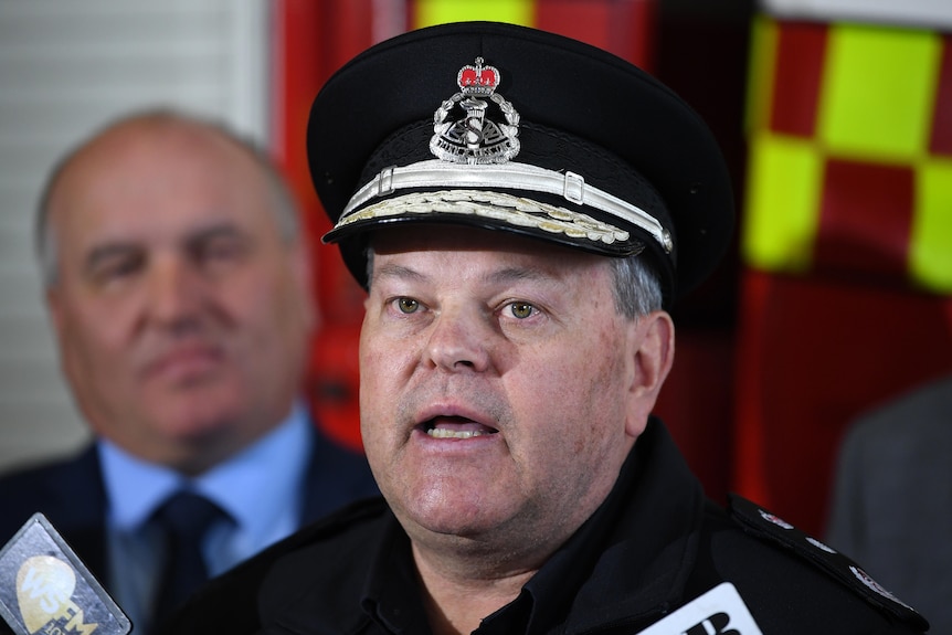 A man in a police hat talking at a press conference 