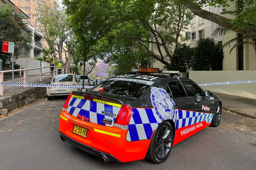 Police officer and police car on a Kirribilli street cordoned off by tape