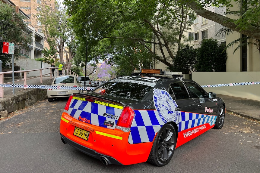 Police officer and police car on a Kirribilli street cordoned off by tape