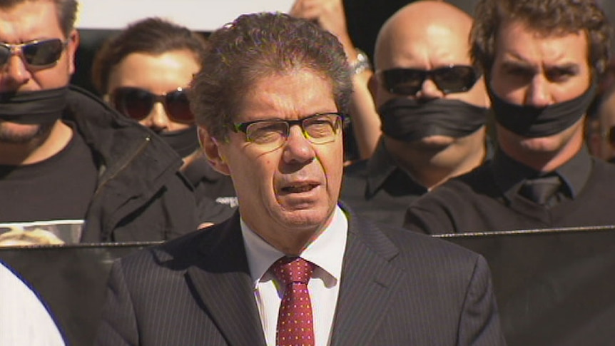 John Battams from the Queensland Council of Unions and gagged protesters.