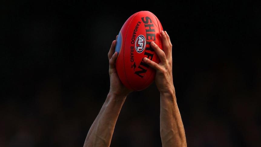 A player marking an AFL ball (Getty Images)