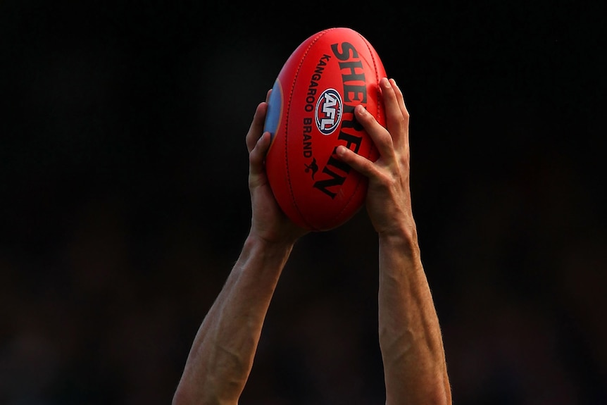 A player marking an AFL ball (Getty Images)