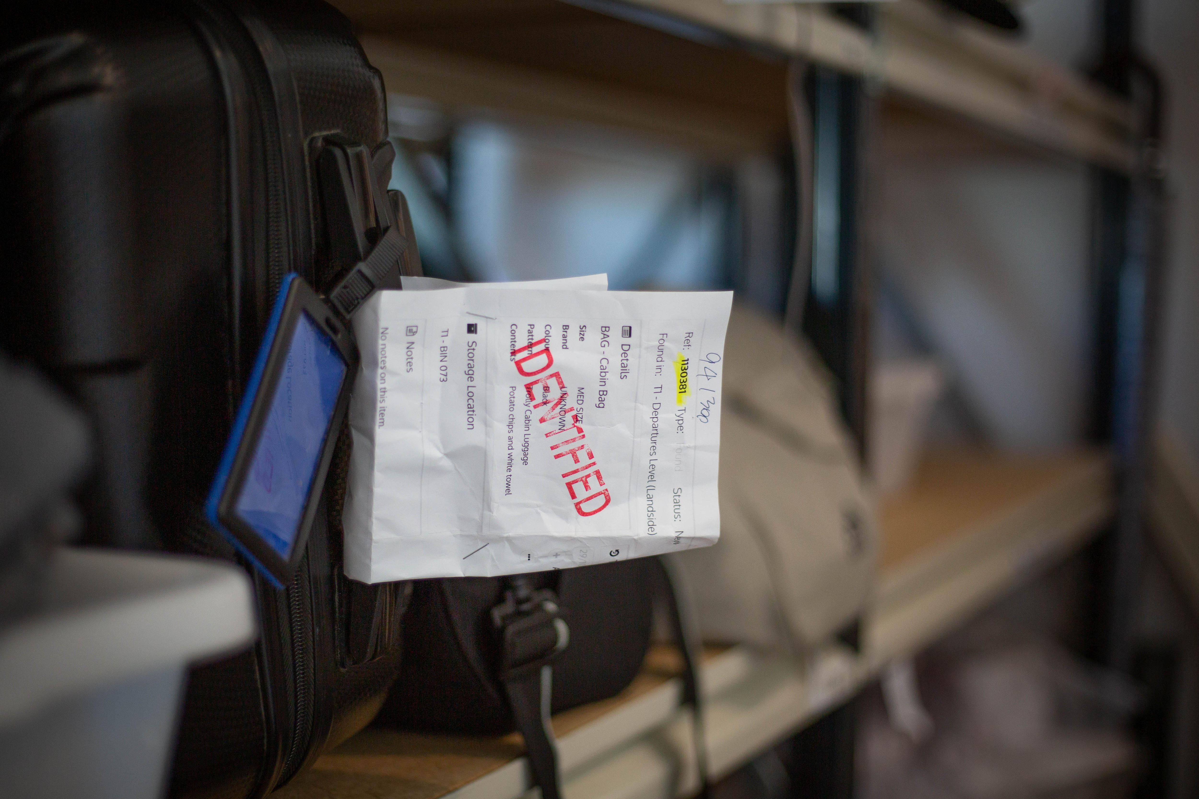 Uma nota com as palavras Identificado estampadas na alça de uma mala.