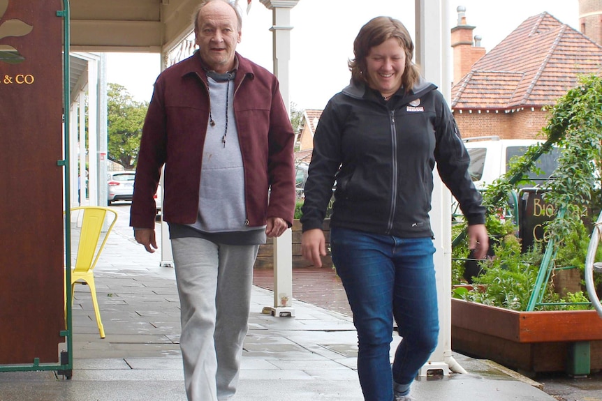 A smiling Lisa Blair walks along a footpath alongside her father Jerry.