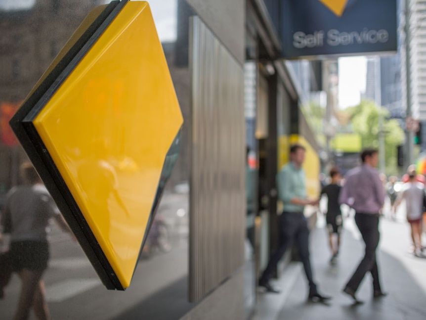 Commonwealth Bank logo with people walking in the background.