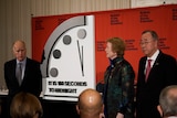 jerry brown, mary robinson and Ban ki-moon stand next to the doomsday clock reading 100 seconds to midnight