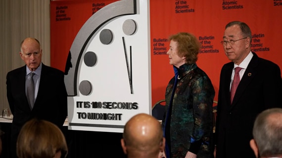 jerry brown, mary robinson and Ban ki-moon stand next to the doomsday clock reading 100 seconds to midnight