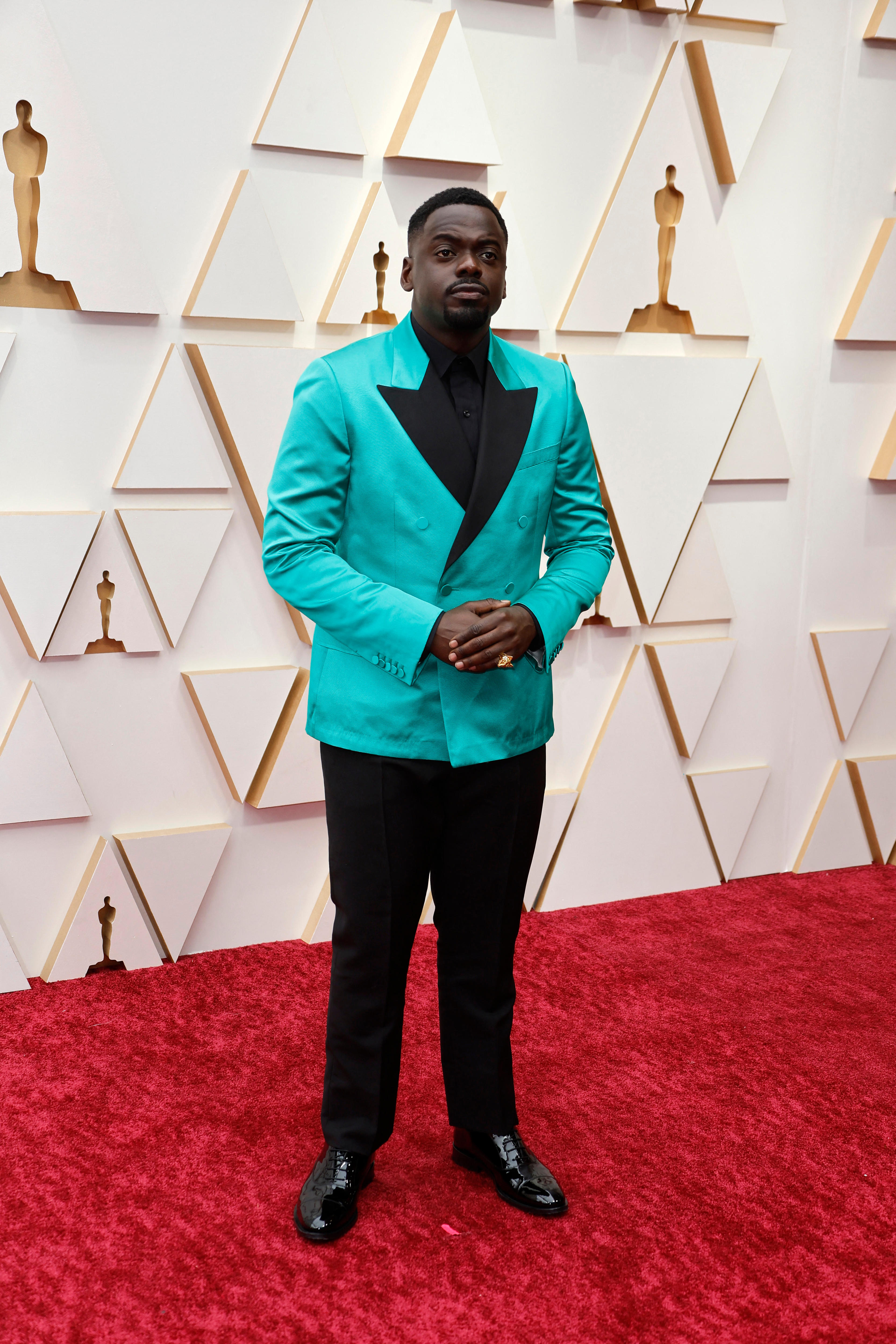 Actor Daniel Kaluuya wearing a turquoise suit jacket and black pants on the Oscars red carpet.