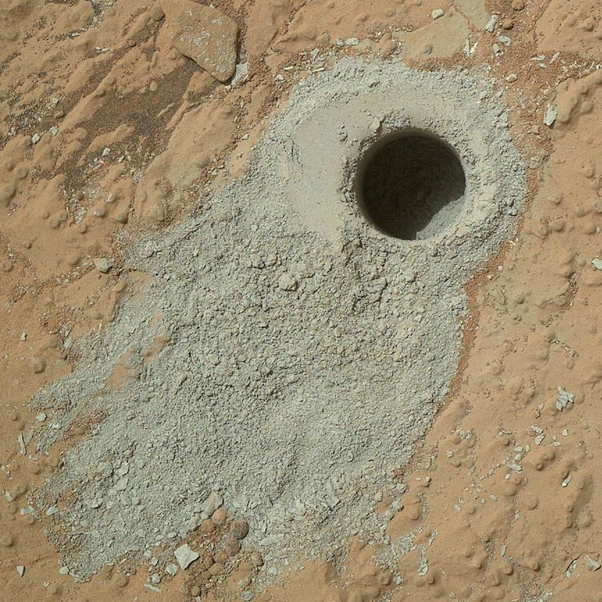 A hole and rock powder drilled by the Curiosity Rover.