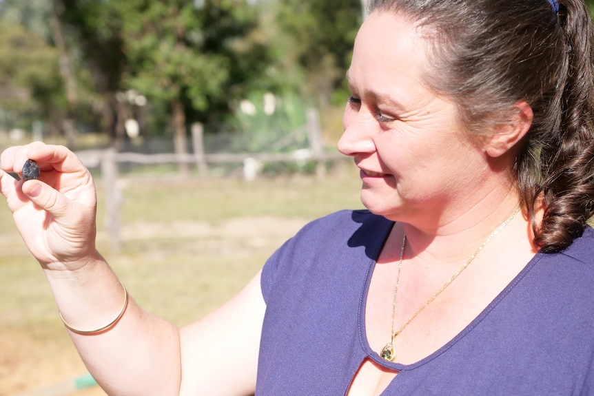 Liz Evens holds a blue sapphire she has just unearthed
