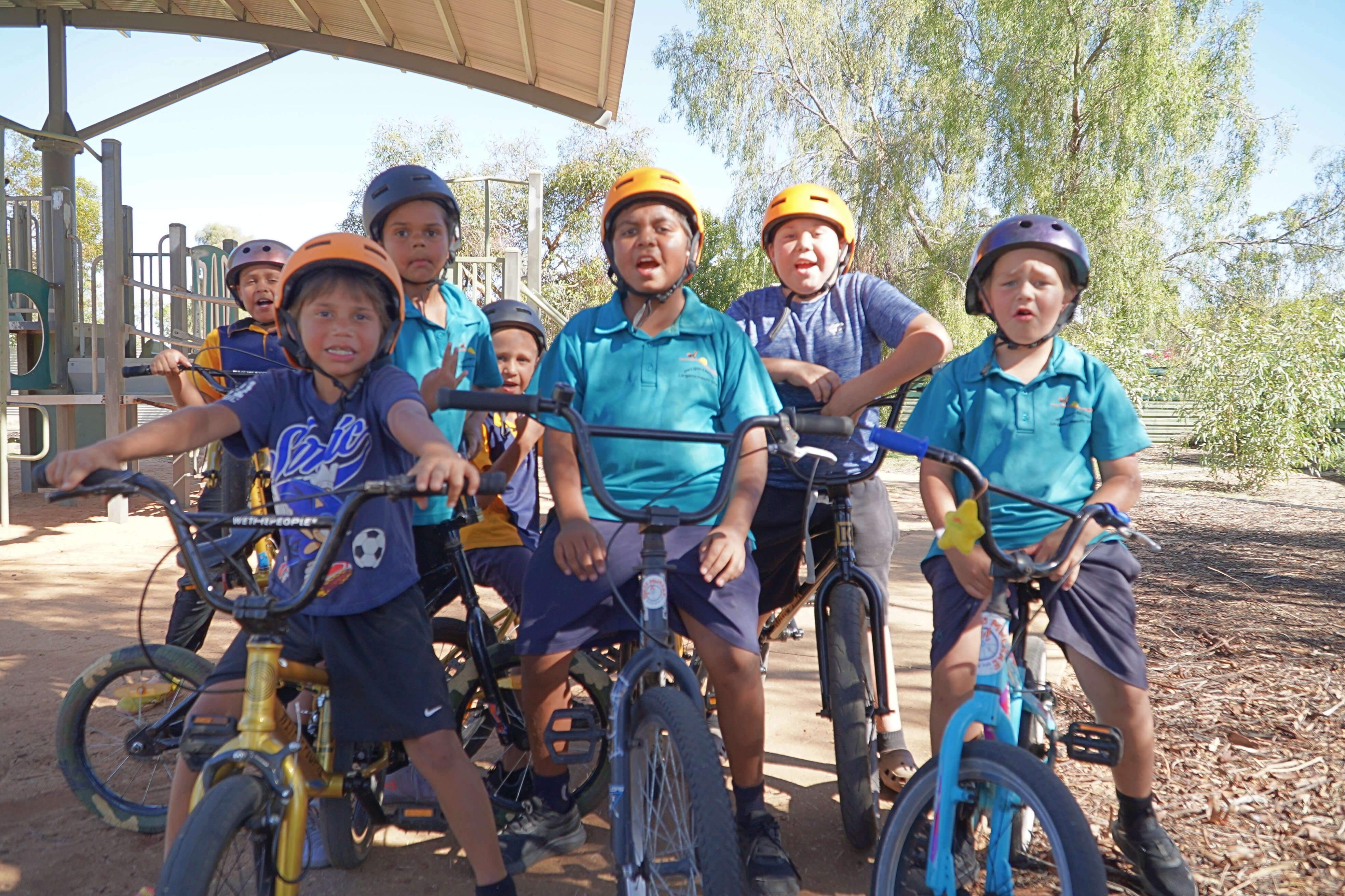 Un grupo de niños se sientan en sus bicicletas en un parque infantil.