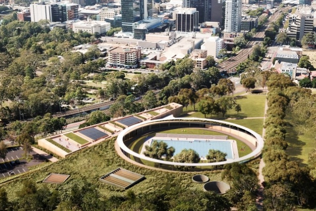 A circular aquatic centre from above, surrounded by trees.
