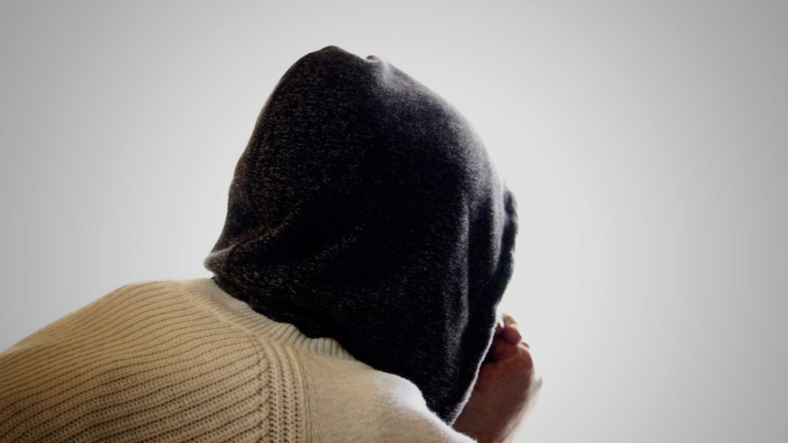 A young woman in a hooded jumper facing away from the camera