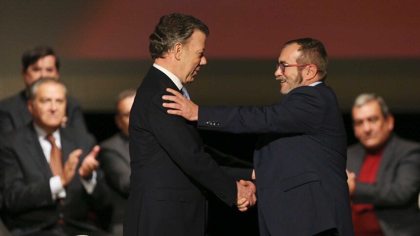 Colombia's President Juan Manuel Santos shakes hands with with FARC leader Rodrigo Londono.
