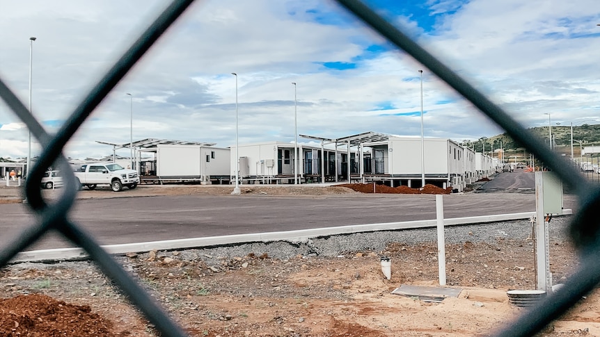 Wide photo of accomodation facility looknig through fence