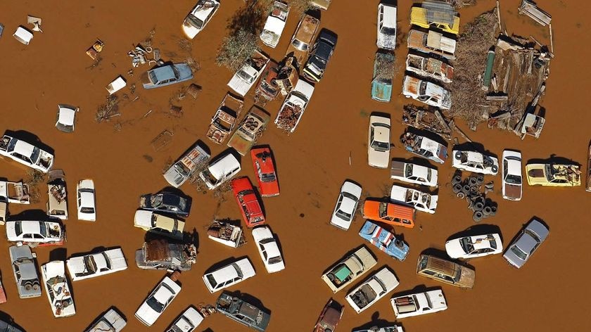 Wrecked cars sit in floodwaters