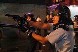A policeman in Hong Kong points a gun.