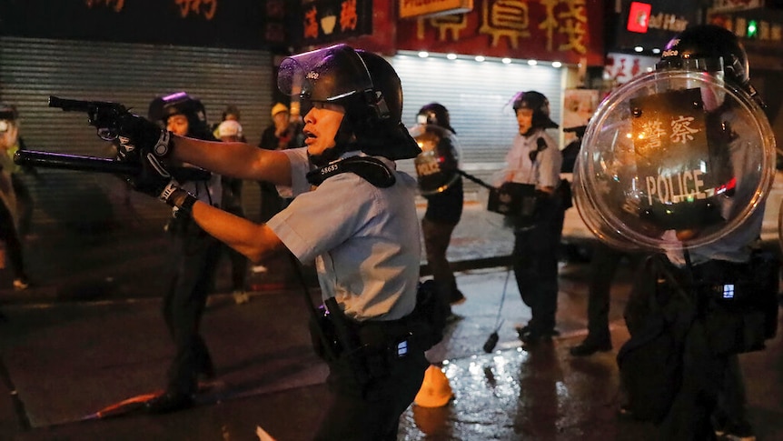 A policeman in Hong Kong points a gun.