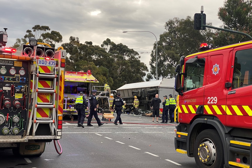 crash site where a truck has rolled over and police and firefighters are on scene