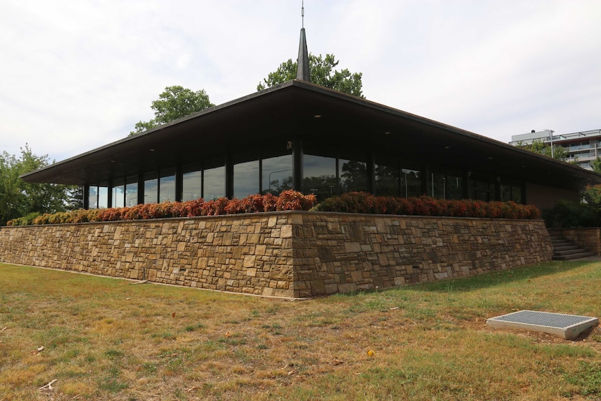 The Anzac Park West cafeteria, a one level, brick building with a spire on top and big plate glass windows.