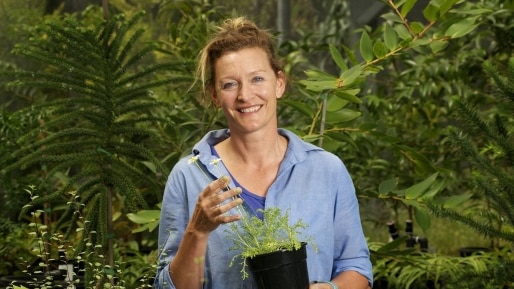 Picture of Meg Hirst wearing a blue shirt iin a garden