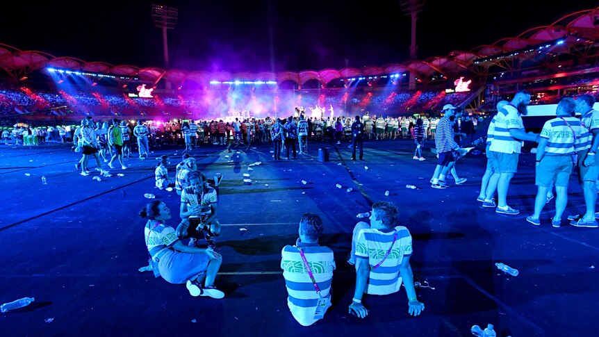 Athletes sit at the back of the stadium during the performances of the closing ceremony