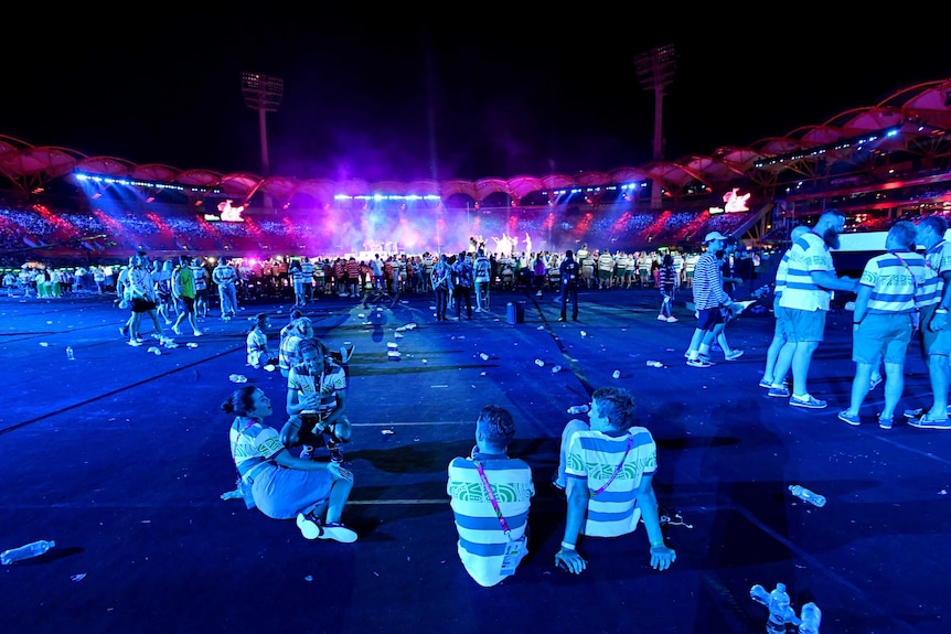 Athletes sit at the back of the stadium during the performances of the closing ceremony