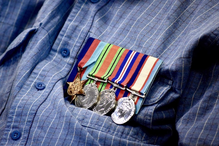 Close up photo of four World War Two medals pinned to a shirt front pocket.