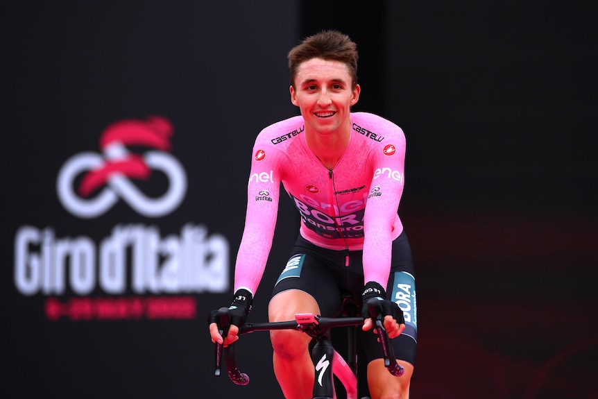 Jai Hindley is pictured in the pink Giro d'Italia leader's top as he crosses the finish line