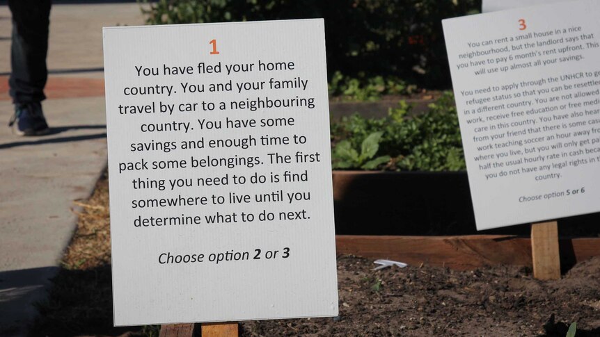 A placard that tells participants you've just fled your home and have two options to choose what comes next.