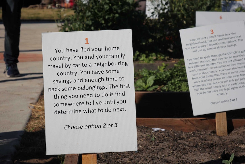 A placard that tells participants you've just fled your home and have two options to choose what comes next.
